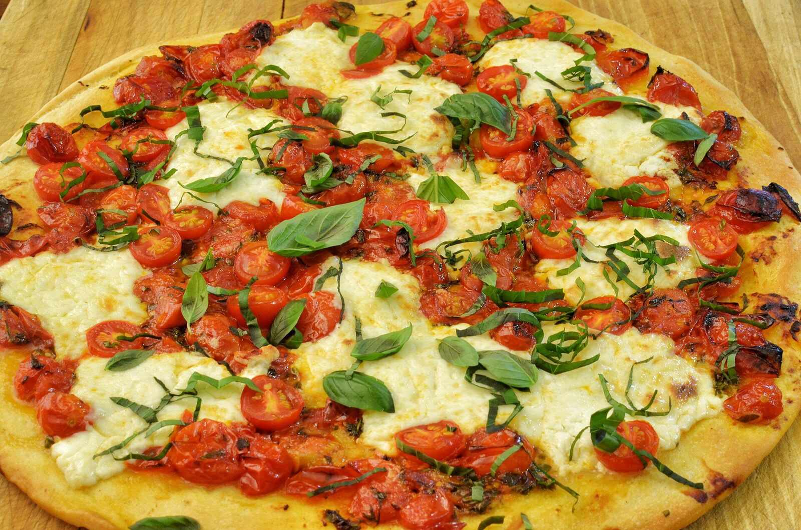 Pizza topped with tomatoes and fresh basil