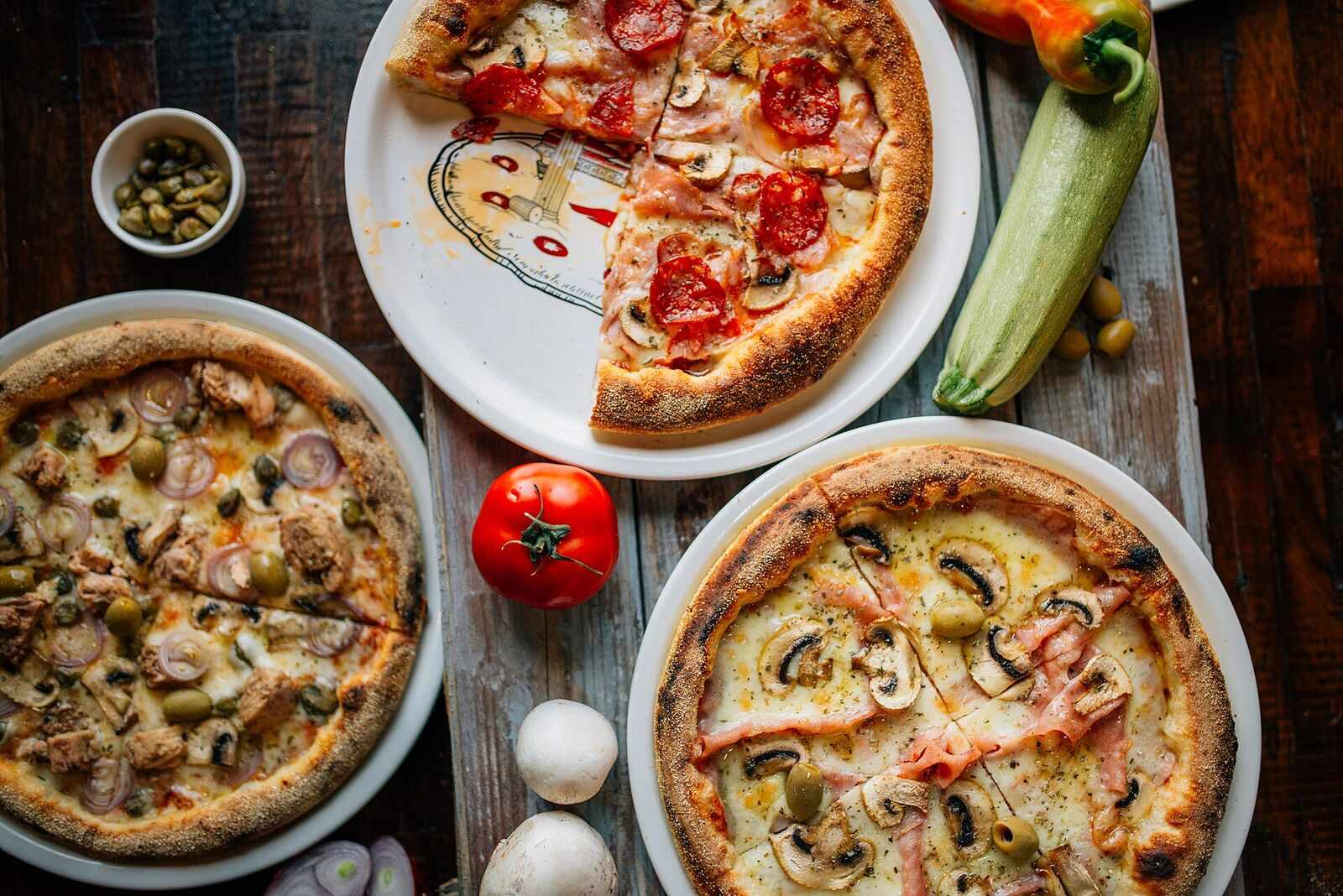 Overhead view of a table spread with several pizzas